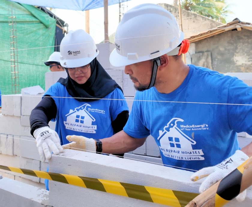MedcoEnergi volunteers building walls of homes in Marga Mulya Village.