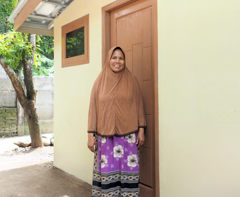 Nunung standing happily in her newly renovated kitchen, showcasing the transformation.